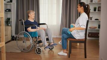Doctor doing rehab with senior woman in wheelchair. Training, sport, recovery and lifting, old person retirement home, healthcare nursing, health support, social assistance, doctor and home service photo