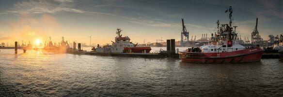 Sunrise in the port of hamburg at a pier for tugboats photo