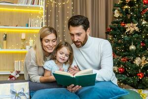 un joven familia gasta hora juntos en Navidad víspera. mamá y papá son leyendo un libro a el hija. foto