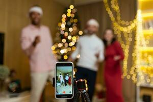 funny friends record reels stories front smartphone camera for social networks during New Year holidays party Christmas Eve celebration. Having fun dancing look pose at camera at home guys having fun photo