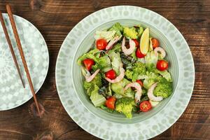 Bowl of salad with broccoli and shrimp. photo