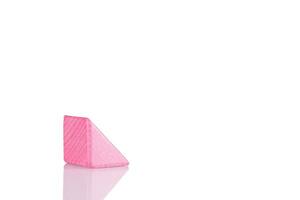 Wooden triangle of pink color on a white background photo