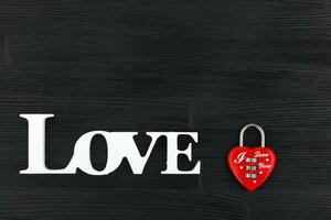 inscription I love you on a black wooden background photo