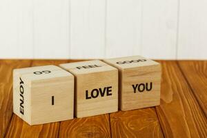 white pieces of paper on clothespins with a heart on a wooden background, a wooden inscription I love you photo