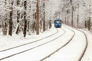 un viejo tranvía moviéndose a través de un bosque de invierno foto