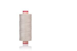 skein of beige color thread macro on a white background photo