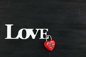 inscription I love you on a black wooden background photo