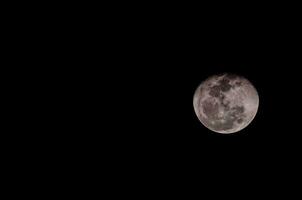 the moon is seen in the dark sky photo