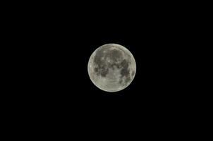 the moon is seen in the dark sky photo