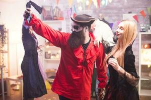 Close friends in pirate and vampire costumes taking a selfie at halloween celebration. photo