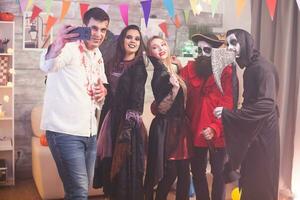 Close friends taking a selfie using smartphone at halloween party. photo