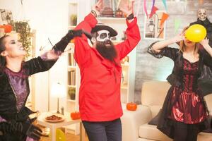Man dressed up like bearded pirate dancing with hands up while celebrating halloween. photo