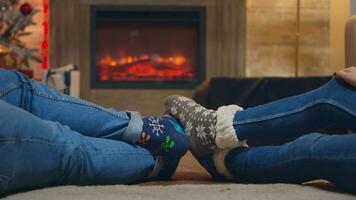 Pareja vistiendo de lana calcetines en frente de hogar en Navidad día. casado Pareja. foto