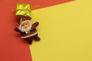 Santa Claus with gift box on red and yellow background. Christmas concept. photo