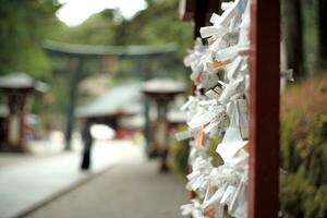 Selective focus on the blessing paper for making the best wish with defocused shrine in background photo