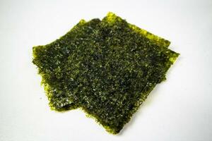 Crispy nori seaweed on white background. Japanese dry seaweed sheets. photo