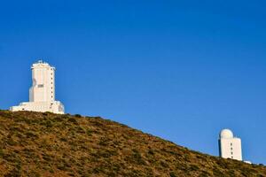 two white towers on top of a hill photo