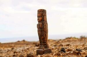 a wooden statue of a man standing on the ground photo