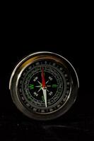 a metal compass on a black background photo