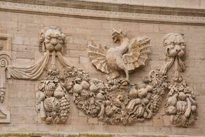 a stone wall with a carving of a lion and other animals photo