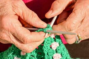 a person's hands are knitting photo