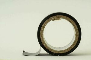 a roll of black tape on a white surface photo