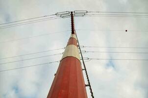 a red and white pole with wires on top photo