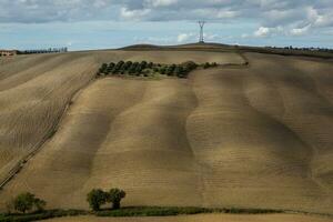 Harvested Fields and meadows landscape in Tuscany, Italy. Wavy country scenery at autumn sunset. Arable land ready for the agricultural season. photo