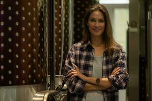 Portrait of a young woman standing in her winery with her arms crossed. photo