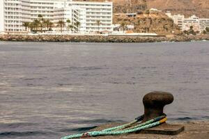 a rope tied to a metal anchor on the side of a pier photo