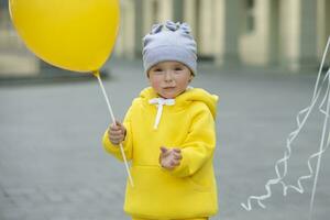 Funny little girl with a balloon. Two-year-old baby looks at the camera. photo