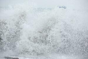 Beautiful foamy breeze from the waves of the sea close-up. photo