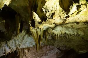 The cave is karst, amazing view of stalactites and stalagnites illuminated by bright light, a beautiful natural attraction in a tourist place. photo