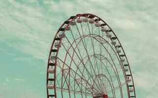 Part of a vintage retro Ferris wheel carousel against the background of the sky in emerald toning. photo