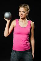 Beautiful young woman is exercising with medicine ball. photo