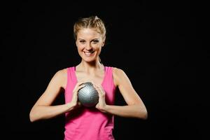 hermosa joven mujer es hacer ejercicio con medicina pelota. foto