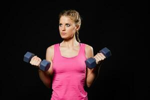 Woman is exercising with dumbbells photo