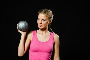 hermosa joven mujer es hacer ejercicio con medicina pelota. foto