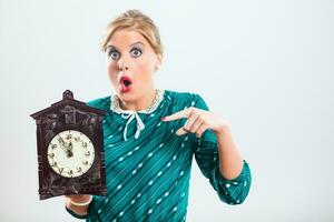 Retro woman in panic pointing at old clock photo