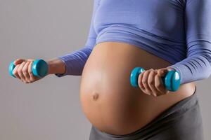 Image of close up stomach of woman exercise with weights on gray background. photo