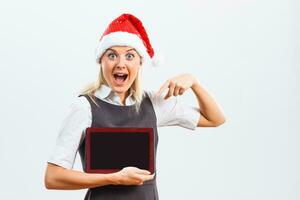 Businesswoman in Santa hat pointing at digital tablet photo