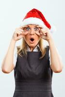 Businesswoman with Santa hat  looking at camera in disbelief photo