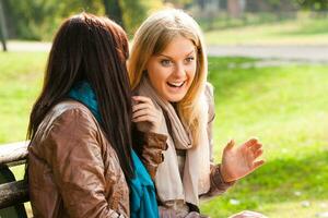 Two woman talking in the park photo