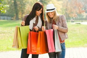 dos mujer participación compras pantalones en el parque foto