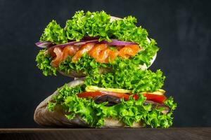 Set of sandwiches in pitas with fresh salmon, ham, vegetables, salad. Homemade sandwiches. Healthy fast food. On the background photo