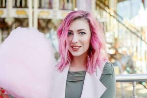 pink hair girl short haircut posing in amusement park on carousel background. photo