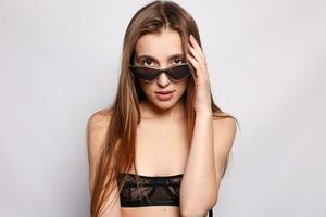 Close up shot of stylish young woman in sunglasses smiling photo