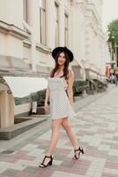 A young teenage girl in a white dress and hat photo