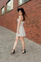 A young teenage girl in a white dress and hat photo