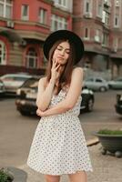 A young teenage girl in a white dress and hat photo